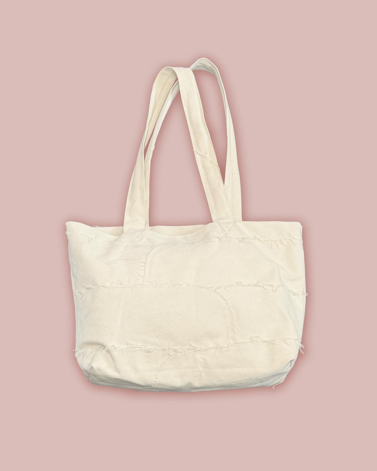 Flat back view of the Asmuss Scraps Tote bag, showing the raw edges of the panelled together bag.