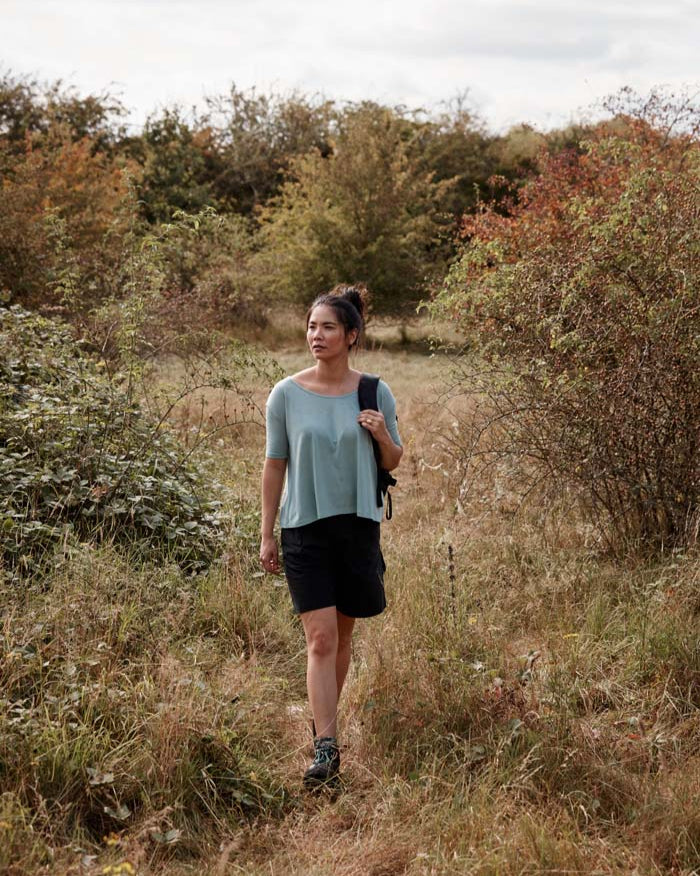 Modern women out for a walk in the countryside wearing the Asmuss A-line T-shirt in Sea Green. An elevated essential t-shirt that drape beautifully in wool blended with temperature regulating 37.5 Technology. Perfect for your everyday adventures.