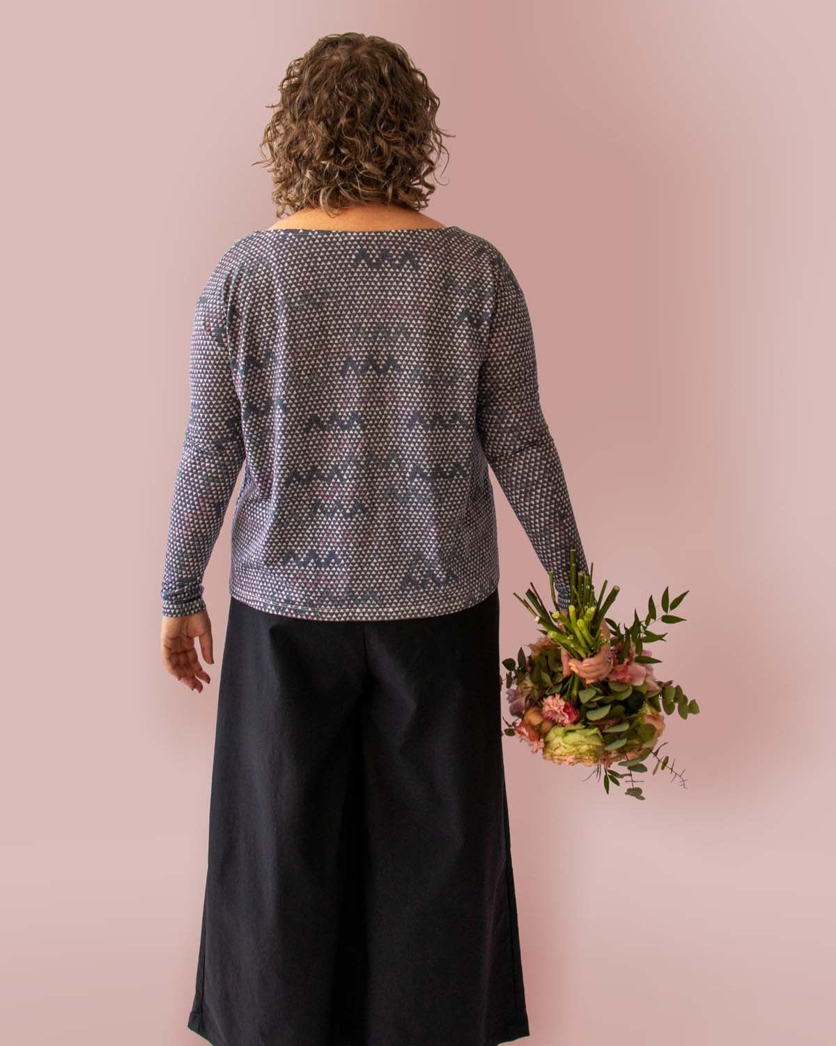 Asmuss Zig Zag A-line Long Sleeve T-shirt in Tech Wool back view on model holding bunch of flowers