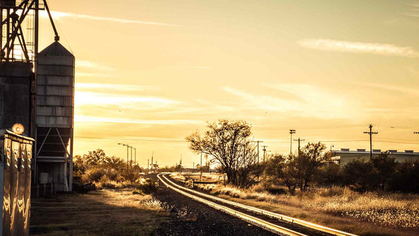 Sunset on rail tracks beside factory silos in Marfa, Texas