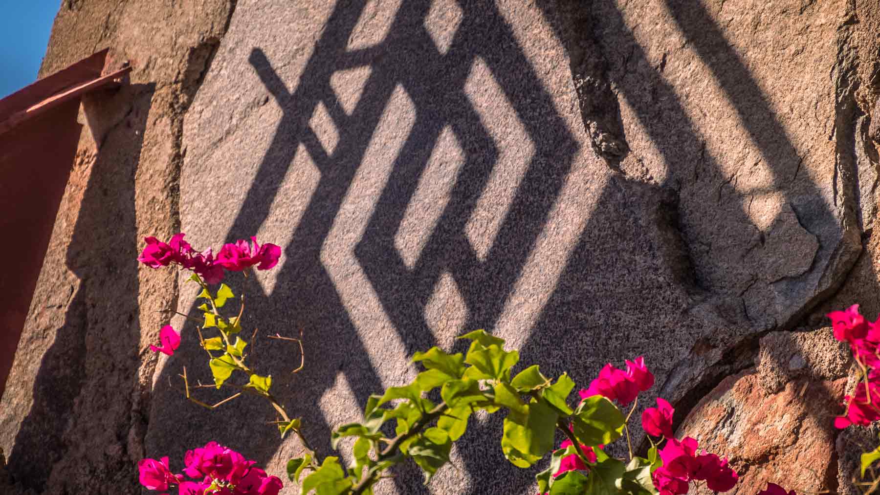 Shadow of the Taliesin West Whirling Arrow symbol on rock wall