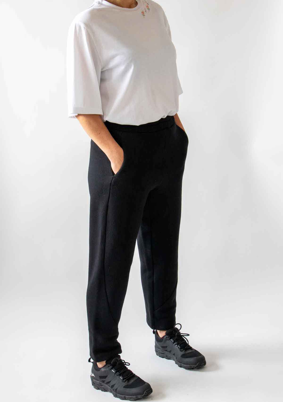 Close up of the woman with her hand in the pocket standing showing the front of the trousers