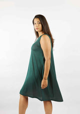 Dark haired woman sideways showing the movement and change in length of the pine green sleeveless Asmuss Drift Dress