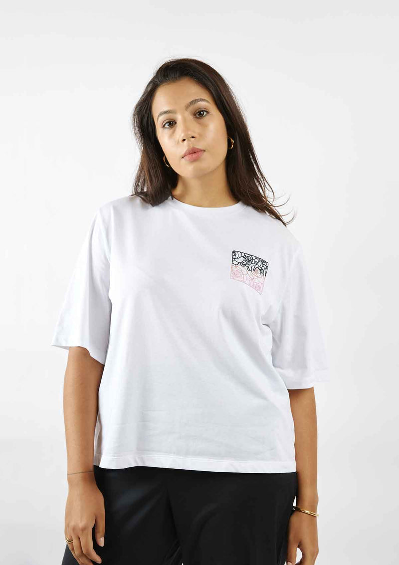 Woman standing with her arms by her sides wearing the Asmuss Evelyn tshirt loose in white with black and pink rose square hand embroidery