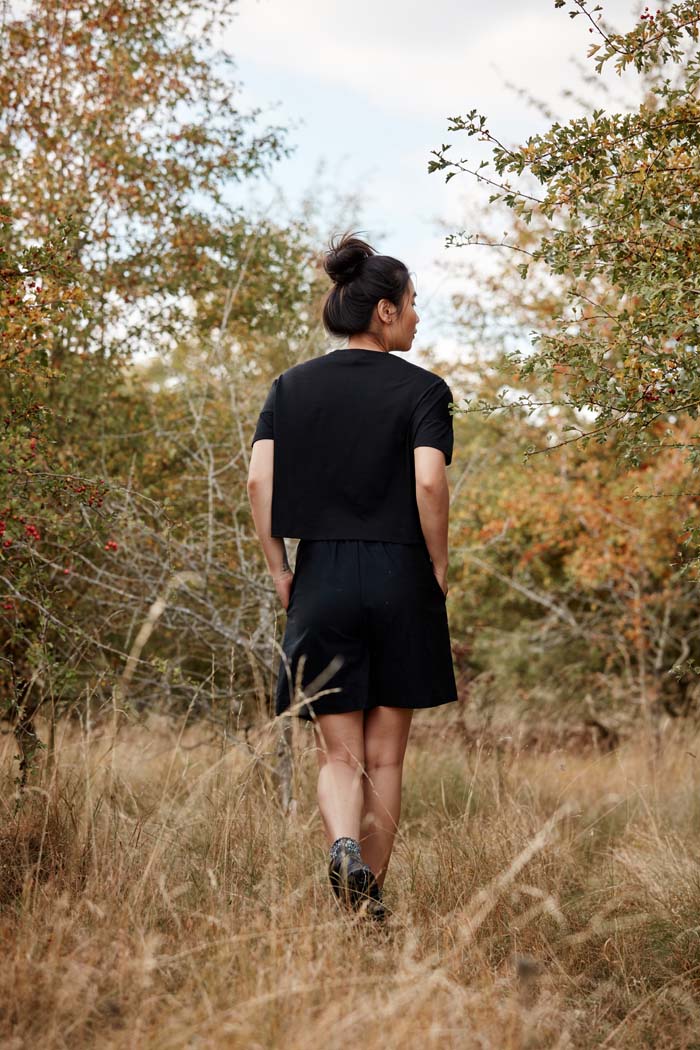 Women walking in the Asmuss Boxy Cropped T-shirt in in Black. Wear it out hiking or at the gallery. It is perfect for any of your everyday adventures made from a blend of wool and temperature regulating 37.5 Technology.