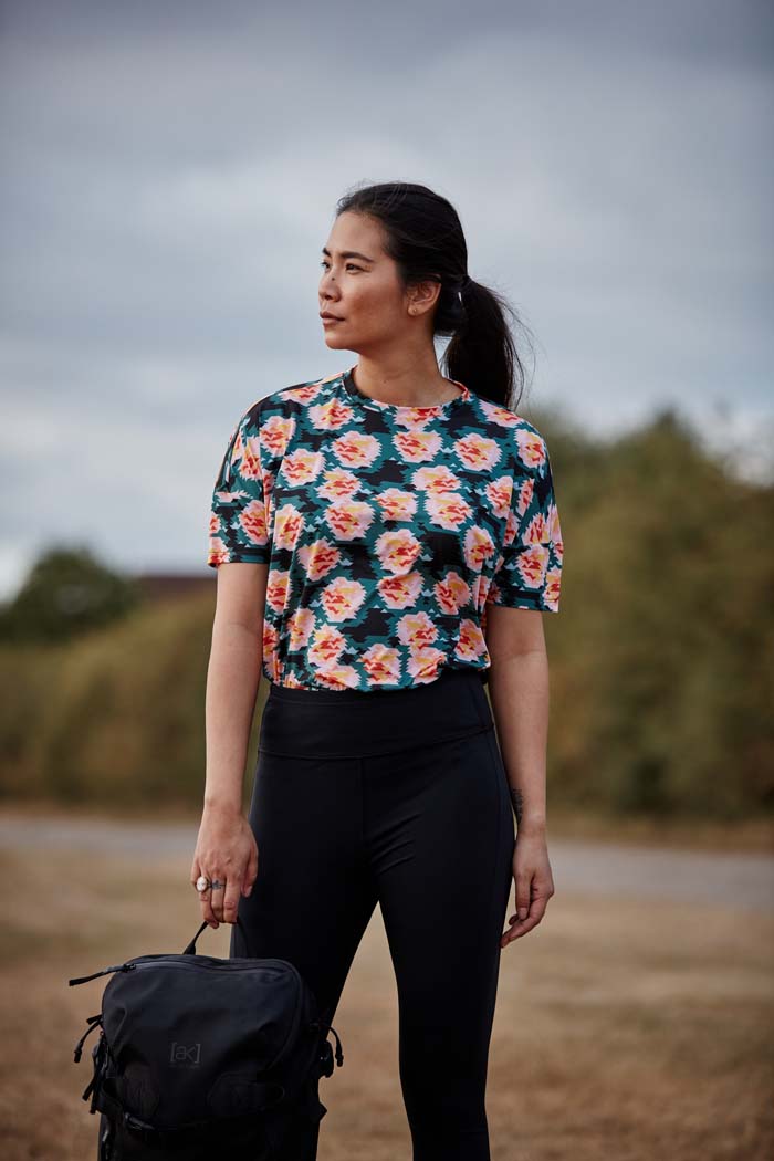 Woman wear the high waisted Asmuss Twisted Leggings with zip detail on lower front leg, pocket in front waistband and drawstring to keep them snug. Made in the UK from recycled nylon and elastane for 4 way stretch. Sustainable activewear that looks great on for all your everyday adventures including lazing on the couch or out running.